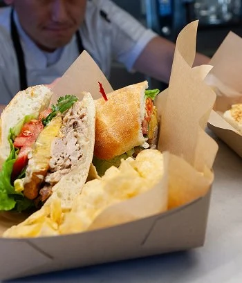 chef serving sandwich and chips